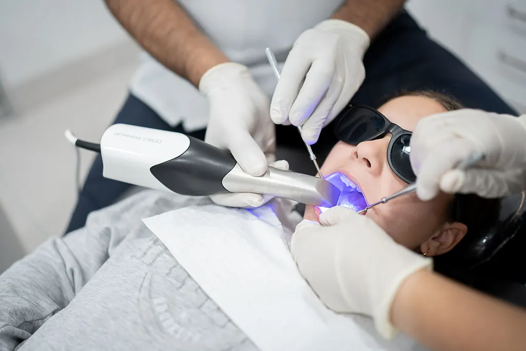 A dentist using a curing light during a same-day crown procedure